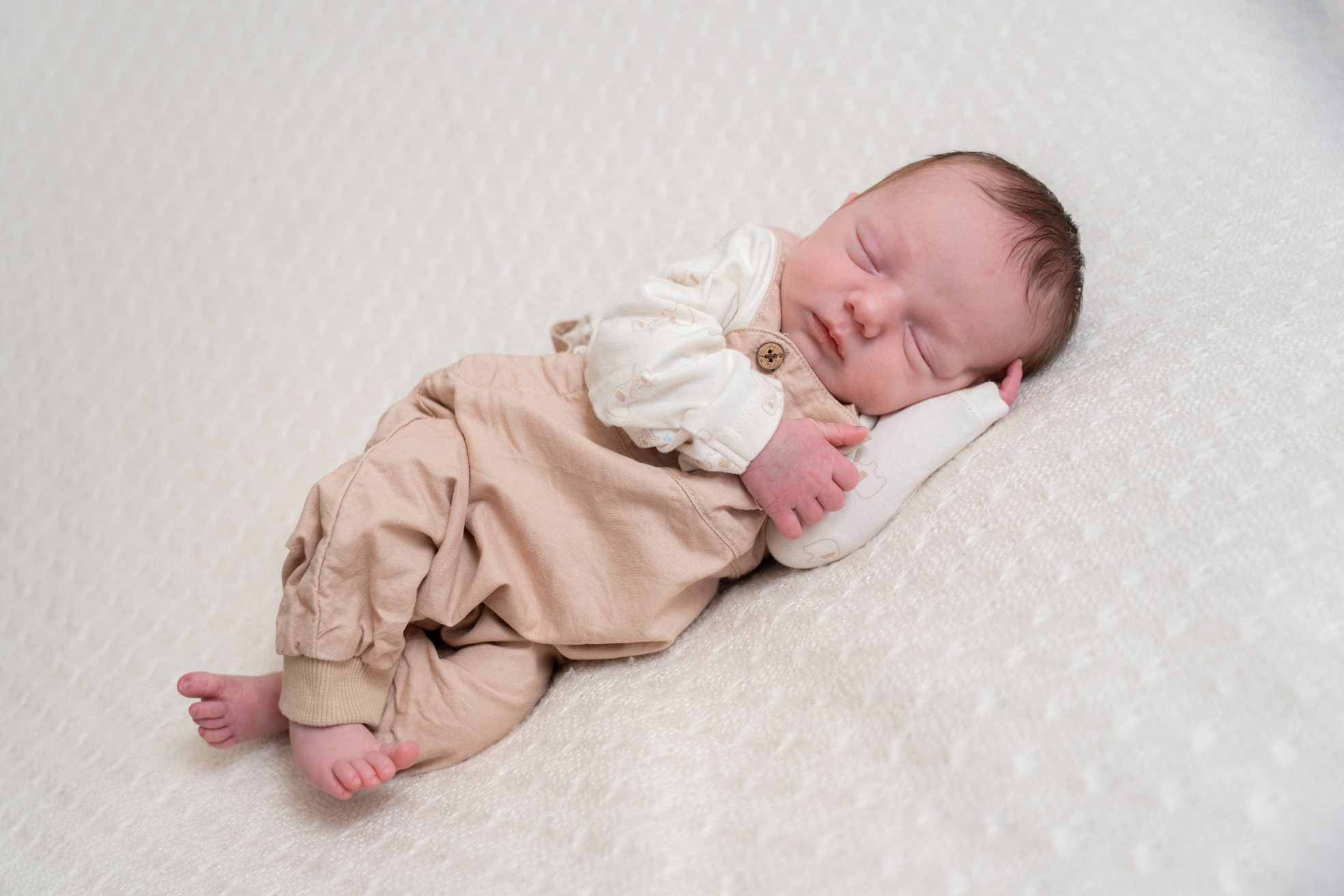 Nouveau-né endormi seul sur une couverture douce en studio à Bressuire.