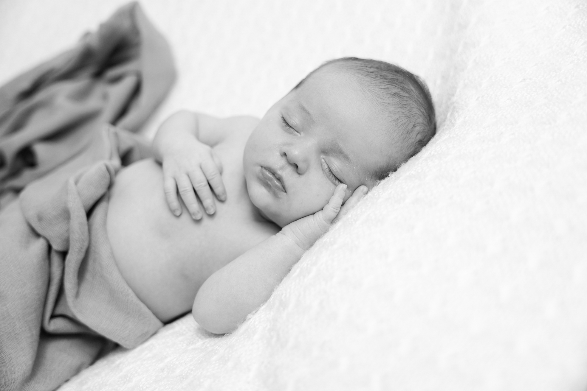 Nouveau-né sur un coussin doux, photographié en studio à Bressuire.