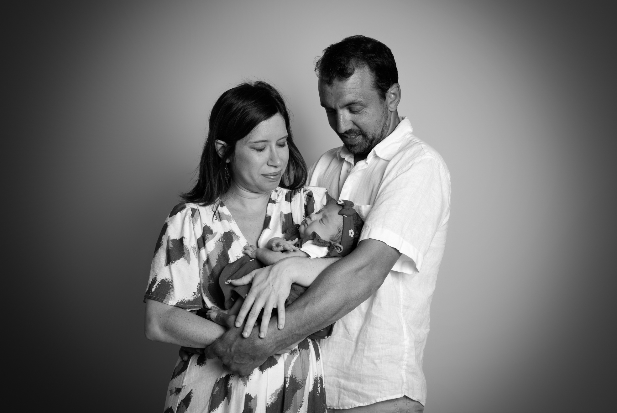 Parents posant avec leur nouveau-né dans les bras, séance photo naissance à Bressuire.
