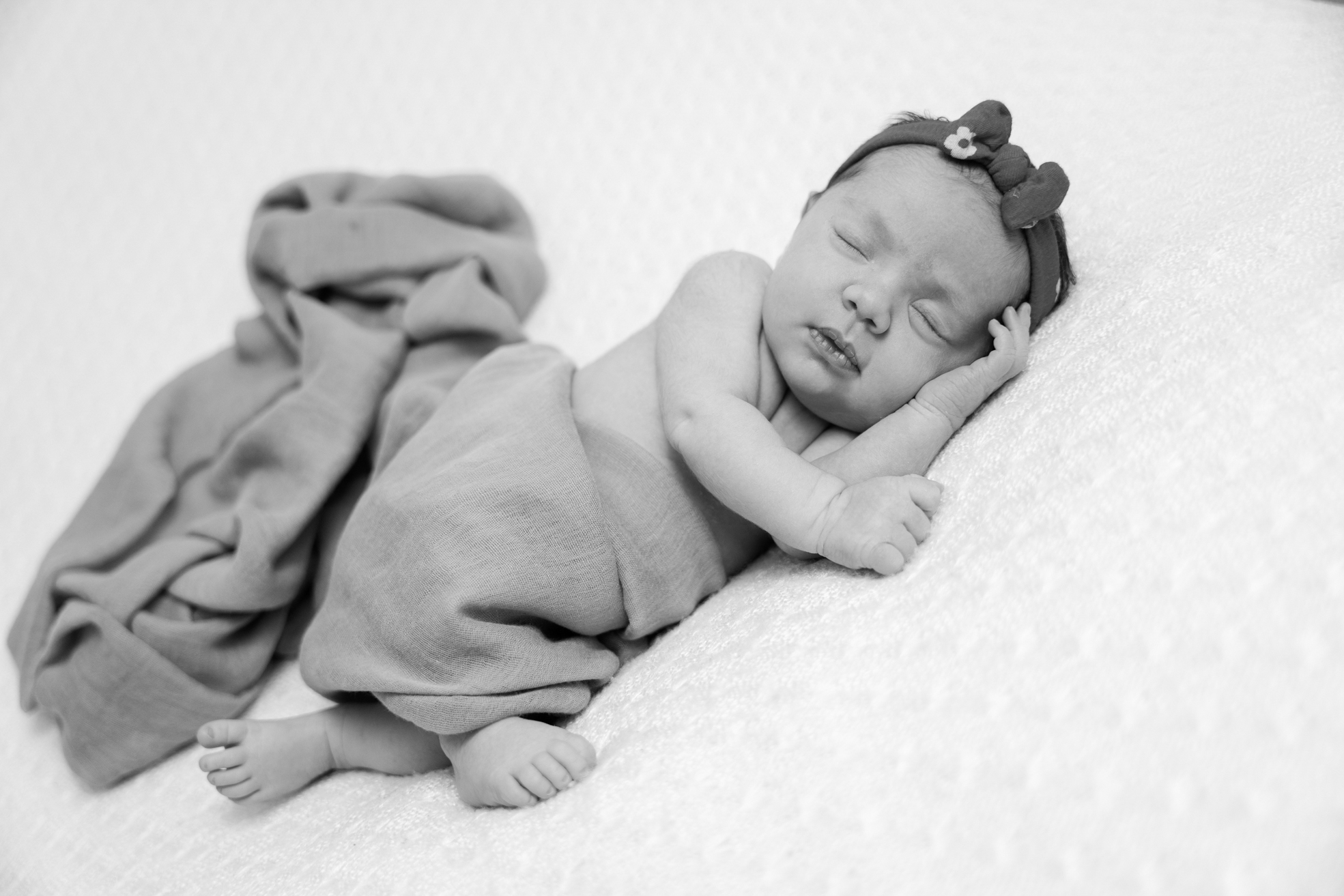 Nouveau-né enveloppé dans une couverture moelleuse, posé seul en studio.