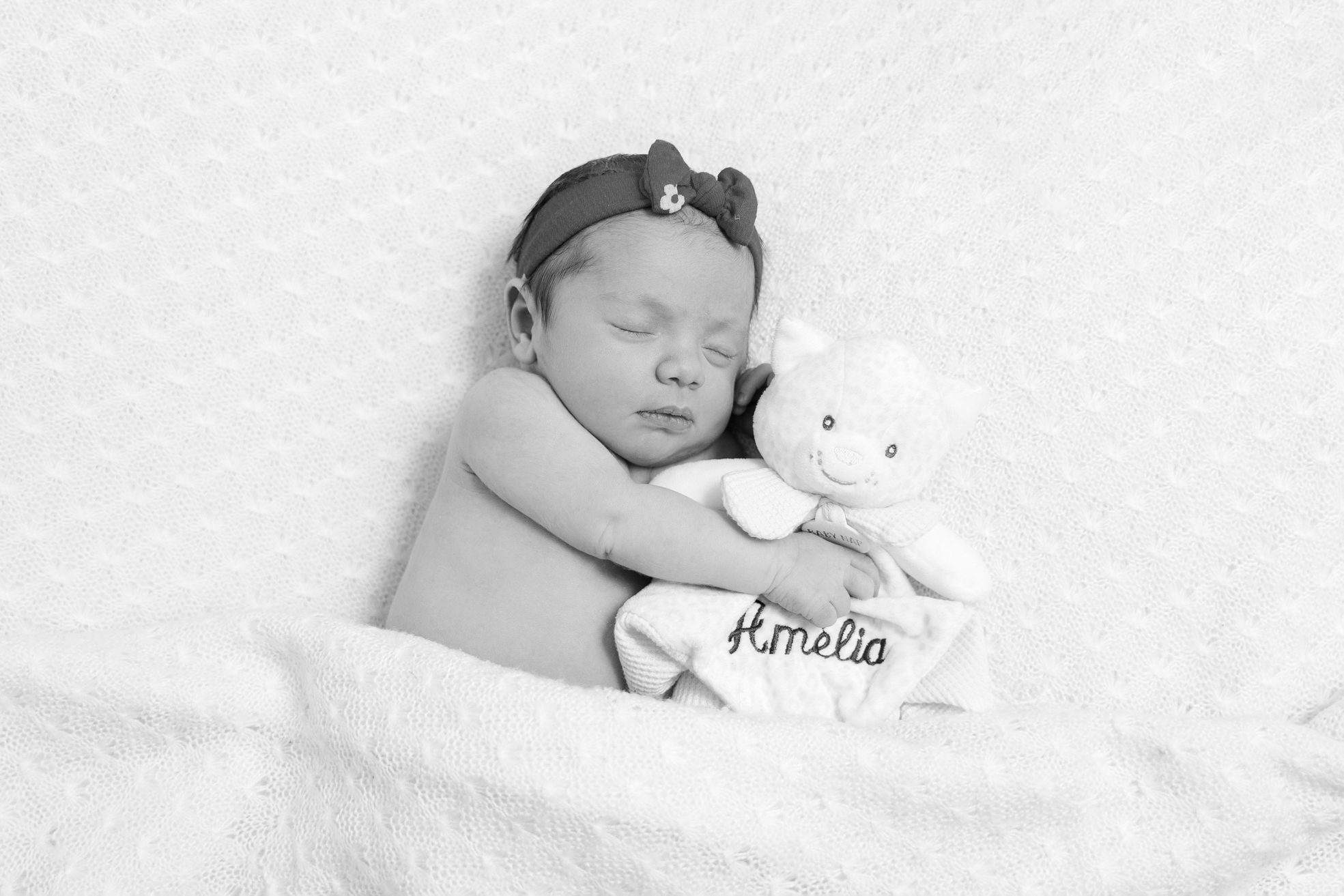 Nouveau-né posé sur une couverture blanche, regard calme en studio à Bressuire.