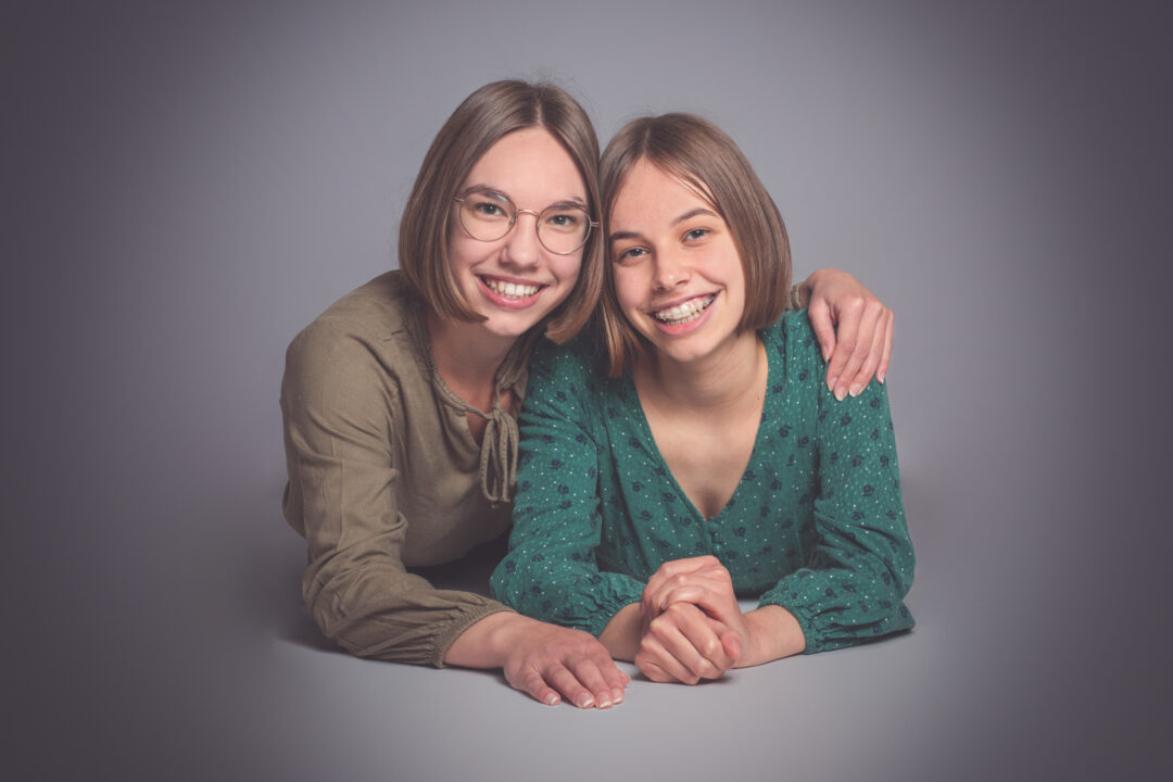 Portrait élégant de deux sœurs posé en studio professionnel