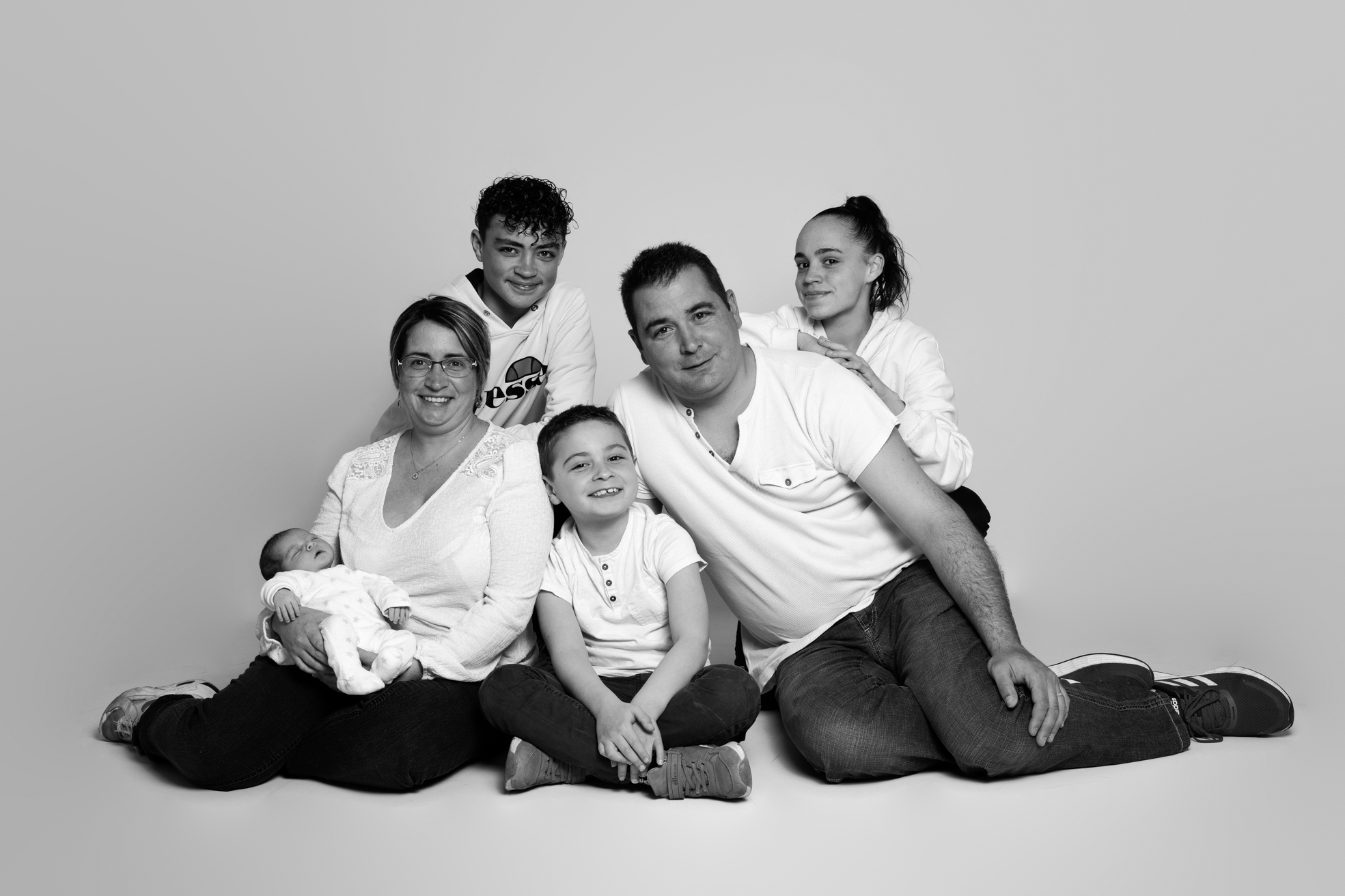 Nouveau-né blotti contre ses parents lors d’une séance photo en studio.