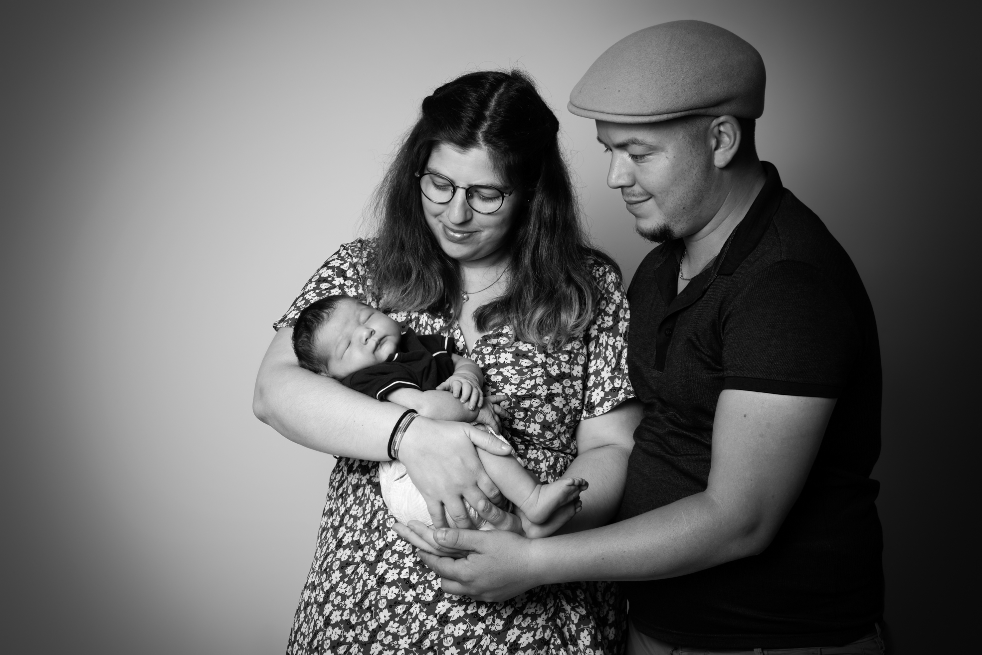 Parents regardant leur nouveau-né avec amour et tendresse en studio.