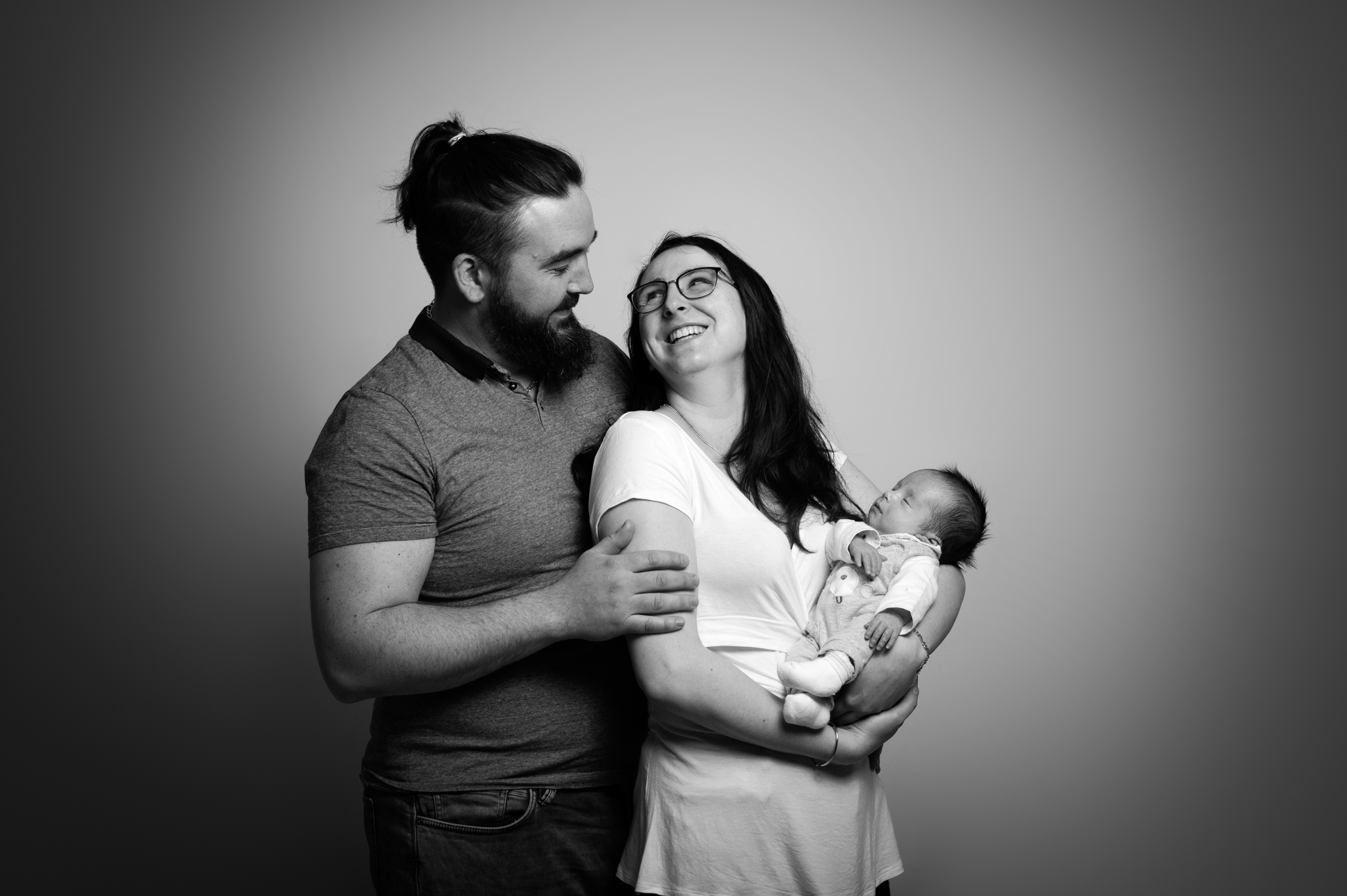 Parents tenant leur nouveau-né lors d’une séance photo naissance en studio à Bressuire.